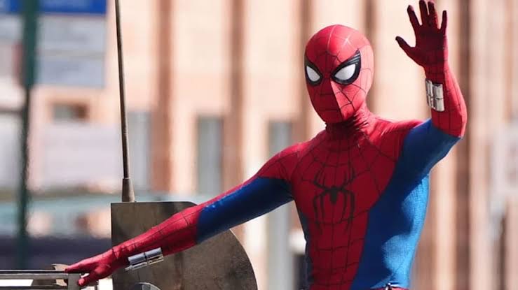 Spider-Man waving to a crowd from a stage